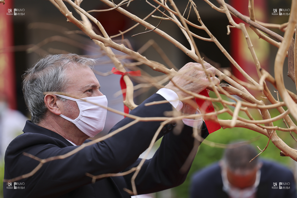 Le Préfet accroche son vœux écrit sur l'arbre à vœux