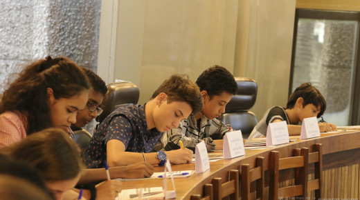 des jeunes participent au championnat d'orthographe en faisant la dictée du Cedaace