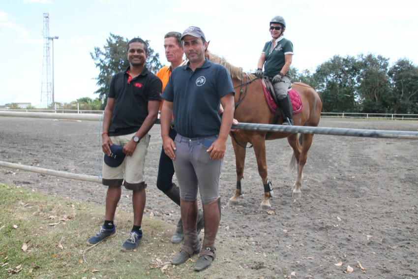 Samuel Silotia, du haras des cocos à Saint-Leu, Gilbert Martino, président de la commission CSO et le formateur Pierre de Bastard devant le manège à cheval et derrière une cavalière sur son cheval