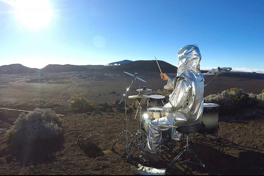 un astronaute joue de la batterie à la Plaine des Sables