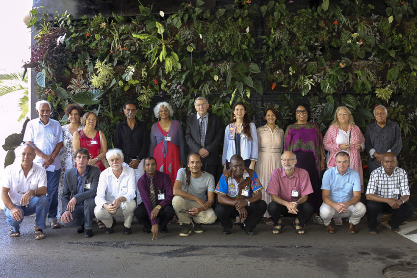 les participants à l'évènement posent pour la photo de groupe, devant le mur végétal du Palais de la Source