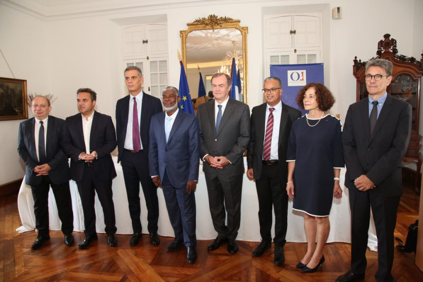 les personnalités posent debout pour la photo de groupe