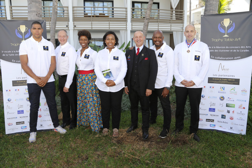 Photo de groupe du jury et des invités, de Gauche à droite, Daniel NARCISSE, Ambassadeur pour la 3ème escale à la Réunion, Stéphane GUENAUD, Argentier au Palais de l'Elysée, Malia METELLA, Ambassadrice pour la Guyane, Béatrice FABIGNON, Fondatrice du Trophy Table Art, Emmanuel FOURNIS, Ambassadeur France de la fondation Paul BOCUSE, Djoe DUNOYER,Responsable logistique concours et David PALANQUE, Barman de l'Hôtel Martinez de Cannes