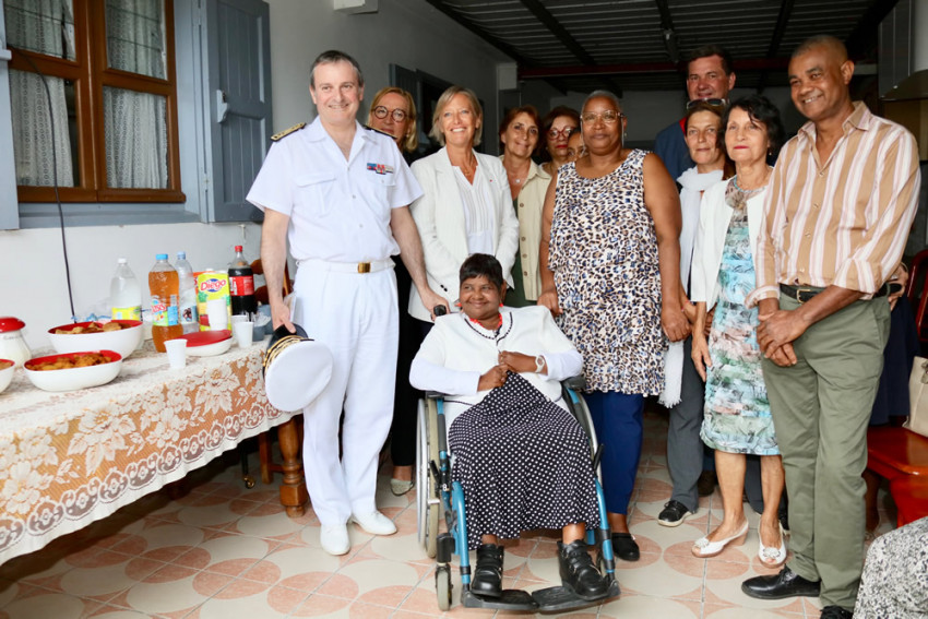Photo de groupe de toute la délégation officielle entourant Aline et sa famille d'accueil