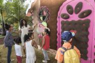 Nassimah dindar avec des enfants devant la maison biscuit