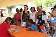 une auteure dédicace ses livres pour les mamans accompagnées de leur enfant