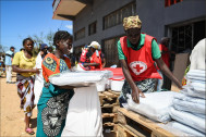 Une volontaire de la Croix-Rouge distribue des kits de reconstruction de l’habitat – ici des bâches - aux sinistrés | Photo PIRO