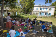 les enfants écoutent un conte à l'ombre dans les jardins