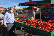 le Président du Département devant le stand d'un marchand de tomates