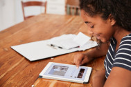 une jeune fille travaille sur une tablette numérique