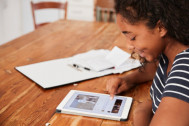 une jeune fille travaille sur une tablette numérique